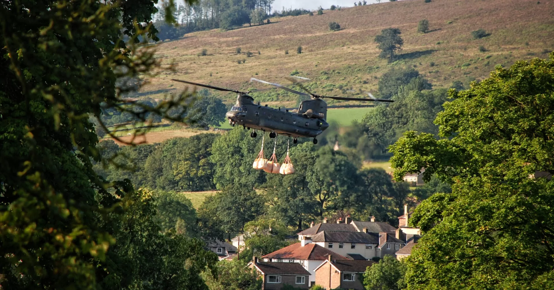 Chinook helicopter carrying bags of ballast in Whaley Bridge, Pe